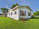 Side view of a white home with a well-kept lawn and neat landscaping at 3736 Knights Station Rd, Lakeland, FL 33810
