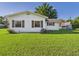Side view of a white home with contrasting brown shutters and lush green lawn at 3736 Knights Station Rd, Lakeland, FL 33810