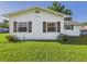 Close-up of a charming white home with brown shutters and a well-manicured lawn at 3736 Knights Station Rd, Lakeland, FL 33810