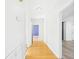 Hallway with hardwood floors leading to a room with blue walls at 3736 Knights Station Rd, Lakeland, FL 33810