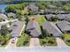 Aerial view of a home with manicured lawn, mature trees, and an inviting paver driveway; surrounded by well-kept homes at 3905 Osprey Pointe Cir, Winter Haven, FL 33884