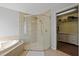 Bathroom featuring glass shower, soaking tub, tile surround, and closet with storage at 3905 Osprey Pointe Cir, Winter Haven, FL 33884