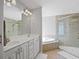 Bathroom features double sinks, a soaking tub, and a glass-enclosed shower at 3905 Osprey Pointe Cir, Winter Haven, FL 33884