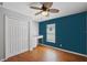 Bedroom with ceiling fan, wood floors, blue accent wall, closet, and built-in desk at 3905 Osprey Pointe Cir, Winter Haven, FL 33884