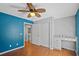 Bedroom with ceiling fan, wood floors, blue accent wall, closet, and built-in desk at 3905 Osprey Pointe Cir, Winter Haven, FL 33884
