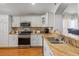 Well-lit kitchen features stainless appliances, granite countertops, and white cabinetry at 3905 Osprey Pointe Cir, Winter Haven, FL 33884