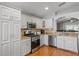 Well-lit kitchen features stainless appliances, granite countertops, and white cabinetry at 3905 Osprey Pointe Cir, Winter Haven, FL 33884