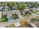 An aerial view showcases a home with a manicured lawn, double car driveway, and a well-kept community street at 4016 Cypress S Lndg, Winter Haven, FL 33884