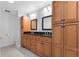 Bathroom featuring a double sink vanity, black granite countertop, and wood cabinets at 4016 Cypress S Lndg, Winter Haven, FL 33884
