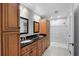 Bathroom featuring a double sink vanity, black granite countertop, wood cabinets and a glass shower at 4016 Cypress S Lndg, Winter Haven, FL 33884