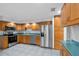 Bright kitchen featuring stainless steel appliances, wood cabinets, and tile flooring at 4016 Cypress S Lndg, Winter Haven, FL 33884