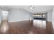 Expansive living room with sleek hardwood flooring, a ceiling fan, and access to an enclosed outdoor patio at 4016 Cypress S Lndg, Winter Haven, FL 33884