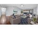 Well-lit living room with modern seating arrangement, dark floors, and sliding glass doors to the lanai at 4016 Cypress S Lndg, Winter Haven, FL 33884