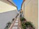 Narrow side yard with small plants and brick walkway at 4016 Cypress S Lndg, Winter Haven, FL 33884