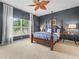 Bedroom features a four-poster bed, neutral carpet, ceiling fan and a window with backyard views at 4088 Dunmore Dr, Lake Wales, FL 33859