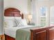 Comfortable bedroom with lots of natural light from the window and a wooden bed frame at 4088 Dunmore Dr, Lake Wales, FL 33859