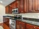 A spacious kitchen features granite countertops, stainless steel appliances, and sleek dark wood cabinetry at 4088 Dunmore Dr, Lake Wales, FL 33859