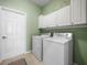 A functional laundry room with modern washer, dryer, and storage cabinets for an organized space at 4088 Dunmore Dr, Lake Wales, FL 33859
