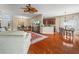 Open-concept living space with hardwood floors flowing into a dining area and a kitchen with dark wood cabinets at 4088 Dunmore Dr, Lake Wales, FL 33859