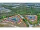 Overhead view of a townhome community featuring mature trees and tranquil ponds at 438 Monroe Cir, Davenport, FL 33896