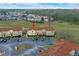 Aerial view of townhomes, parking, and adjacent green spaces within the community at 438 Monroe Cir, Davenport, FL 33896