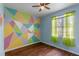 Bright bedroom with unique wall art and wood laminate flooring at 438 Monroe Cir, Davenport, FL 33896