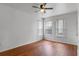 Bright bedroom with hardwood floors, three windows with blinds, and a ceiling fan at 438 Monroe Cir, Davenport, FL 33896