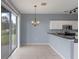 Kitchen and eat-in dining area offer stainless appliances, white cabinets, and backyard view at 438 Monroe Cir, Davenport, FL 33896