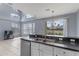 Kitchen with stainless steel sink, and a view of the living room with high ceilings and clerestory windows at 438 Monroe Cir, Davenport, FL 33896