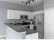 Modern kitchen featuring white cabinets, stainless steel appliances, and a breakfast bar for casual dining at 438 Monroe Cir, Davenport, FL 33896