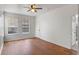 Hardwood living room with a ceiling fan, two large windows, and access to another room at 438 Monroe Cir, Davenport, FL 33896