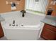 Close-up of a garden tub with a tile surround and granite countertops at 451 Montara Dr, Davenport, FL 33897