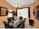 Formal dining room with glass-top table, black chairs, a chandelier, and a large window with white blinds at 451 Montara Dr, Davenport, FL 33897
