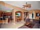 Open-concept living room featuring tile floors, a ceiling fan, and easy access to kitchen, stairs and entrance at 451 Montara Dr, Davenport, FL 33897