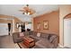 Spacious living room features a large sectional sofa, a ceiling fan, and two decorative paintings on the walls at 451 Montara Dr, Davenport, FL 33897