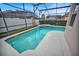 Sparkling in-ground pool and spa inside lanai, surrounded by lush landscaping, perfect for relaxation and enjoyment at 451 Montara Dr, Davenport, FL 33897