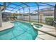 Sparkling in-ground pool and spa inside lanai, surrounded by lush landscaping, perfect for relaxation and enjoyment at 451 Montara Dr, Davenport, FL 33897