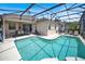 A beautiful lanai with a swimming pool, outdoor seating, and a well-maintained backyard with green grass at 451 Montara Dr, Davenport, FL 33897