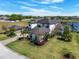 Aerial view of an estate home with lush landscaping, a detached garage, and a serene lake in the background at 4717 Emerald Palms Ct, Winter Haven, FL 33884