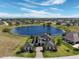 Expansive aerial view showcasing a grand estate home nestled on a lake with lush landscaping and a private setting at 4717 Emerald Palms Ct, Winter Haven, FL 33884