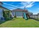 Spacious backyard with well-maintained lawn featuring a wooden playset with swings and slide for entertainment at 4717 Emerald Palms Ct, Winter Haven, FL 33884