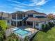 Spacious backyard with a pool, covered patio, and lush landscaping, perfect for outdoor entertaining and relaxation at 4717 Emerald Palms Ct, Winter Haven, FL 33884