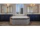 Modern bathroom with a large soaking tub tiled with decorative tile and dual vanities at 4717 Emerald Palms Ct, Winter Haven, FL 33884