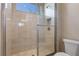 Modern bathroom shower with glass door, neutral tile, and built-in shelf at 4717 Emerald Palms Ct, Winter Haven, FL 33884