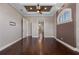 Bedroom with dark hardwood floors, coffered ceiling, fan, and arched window at 4717 Emerald Palms Ct, Winter Haven, FL 33884
