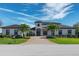 Elegant home featuring a symmetrical design, manicured landscaping, and a brick driveway with a welcoming entrance at 4717 Emerald Palms Ct, Winter Haven, FL 33884