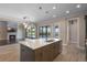 This spacious kitchen island includes a sink and stainless-steel dishwasher, with a lovely view of the stone fireplace at 4717 Emerald Palms Ct, Winter Haven, FL 33884