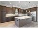 Well-equipped kitchen featuring stainless steel appliances, a large island, and stylish dark wood cabinetry at 4717 Emerald Palms Ct, Winter Haven, FL 33884