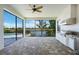 Covered lanai featuring an outdoor kitchen, screened enclosure, and views of the pool and lake at 4717 Emerald Palms Ct, Winter Haven, FL 33884