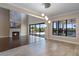 A spacious living room with a stone fireplace, stylish light fixtures, and a view of the pool outside through sliding doors at 4717 Emerald Palms Ct, Winter Haven, FL 33884